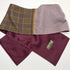 A folded men's neck warmer scarf with a brown and purple plaid pattern, a light purple herringbone side, and a deep burgundy satin lining.